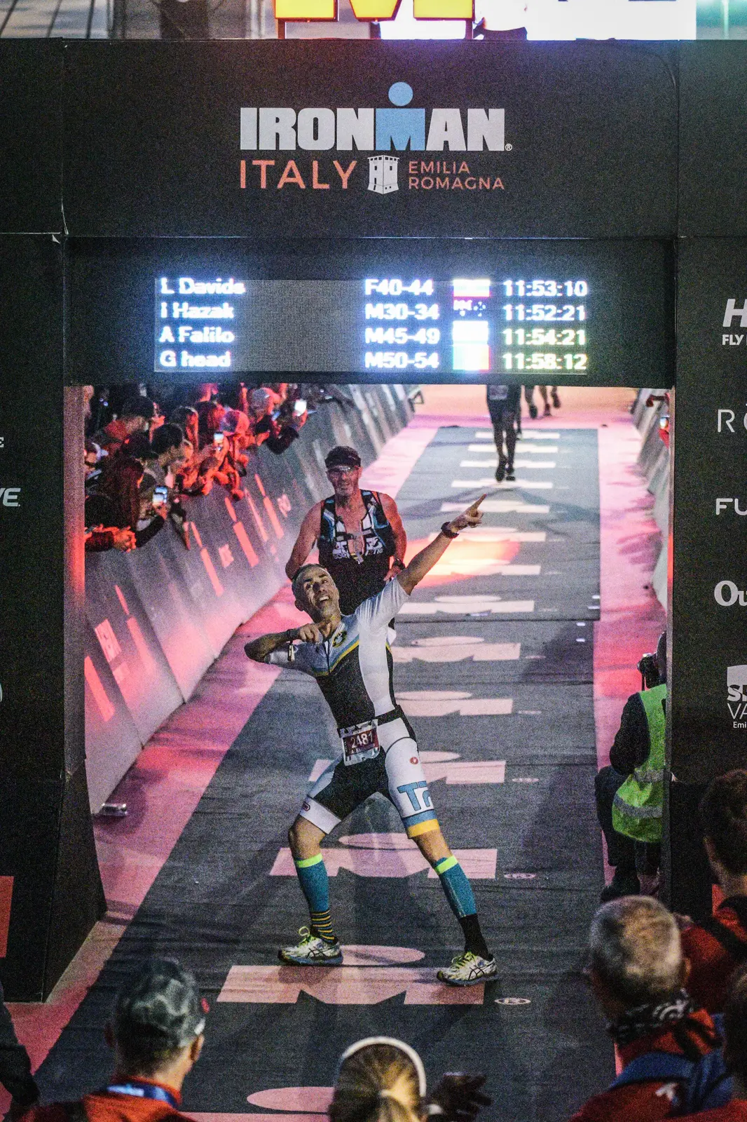 Atleta Team Panda festeggia un arrivo Ironman in atmosfera serale