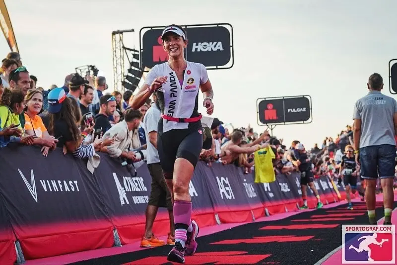 Atleta Team Panda sorride sul tappeto rosso del traguardo