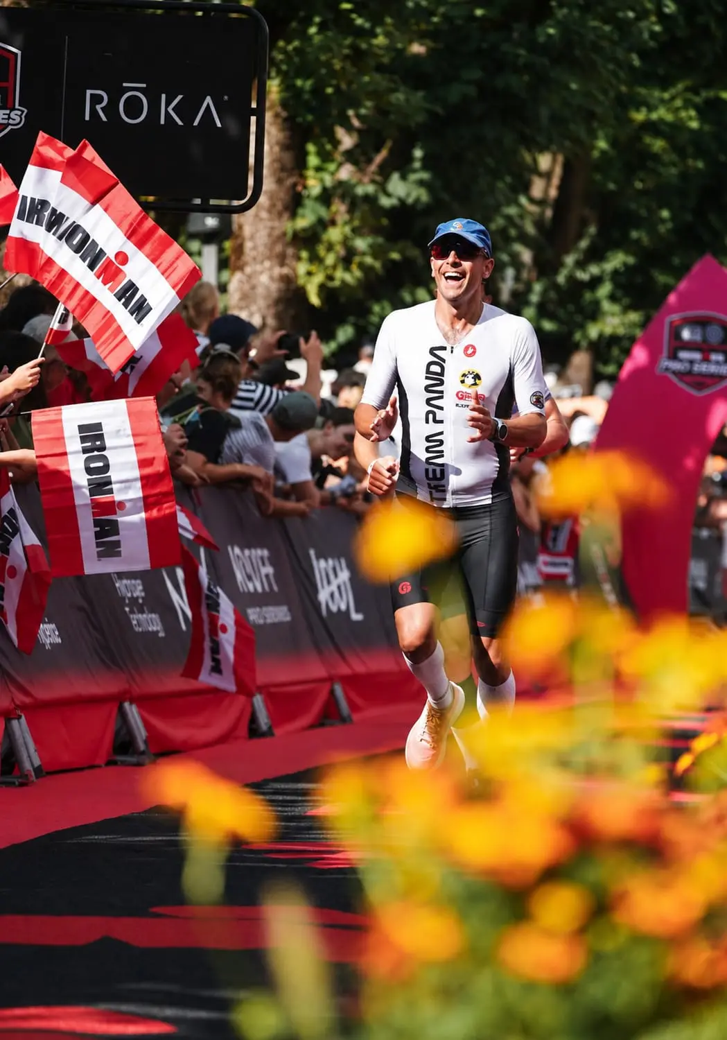 Arrivo al traguardo di un atleta Team Panda con un mazzo di fiori